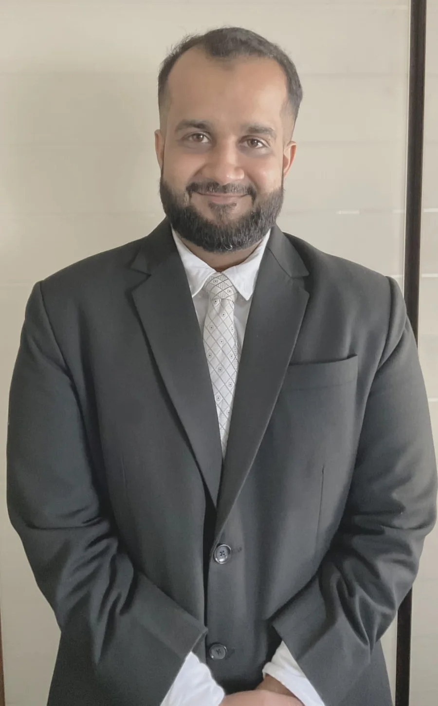 Advocate Mohd Taha Shaikh wearing a black suit and tie